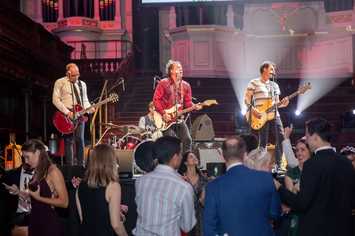 The Pragmatics performing as guests dance in front of the stage at Sydney Town Hall